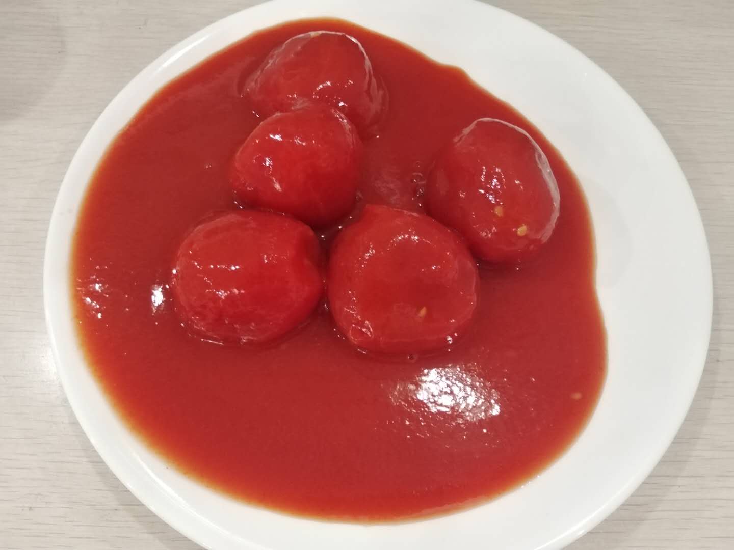 Hele gepelde tomaat-tomaat met tomatensap in hoge concentratie